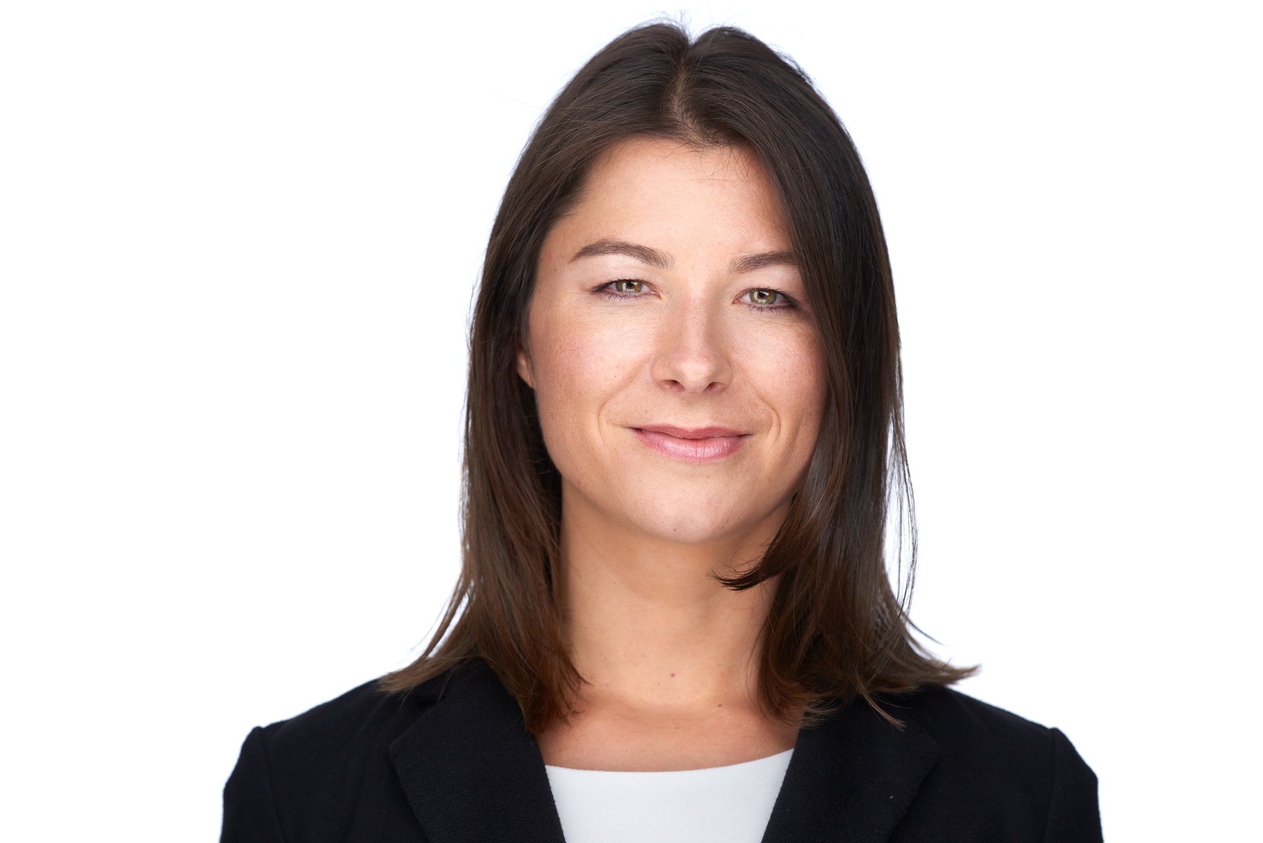 Businessportrait einer Frau mit langen dunklen Haaren im schwarzen Blazer vor weißem Hintergrund, fotografiert im Studio in Köln