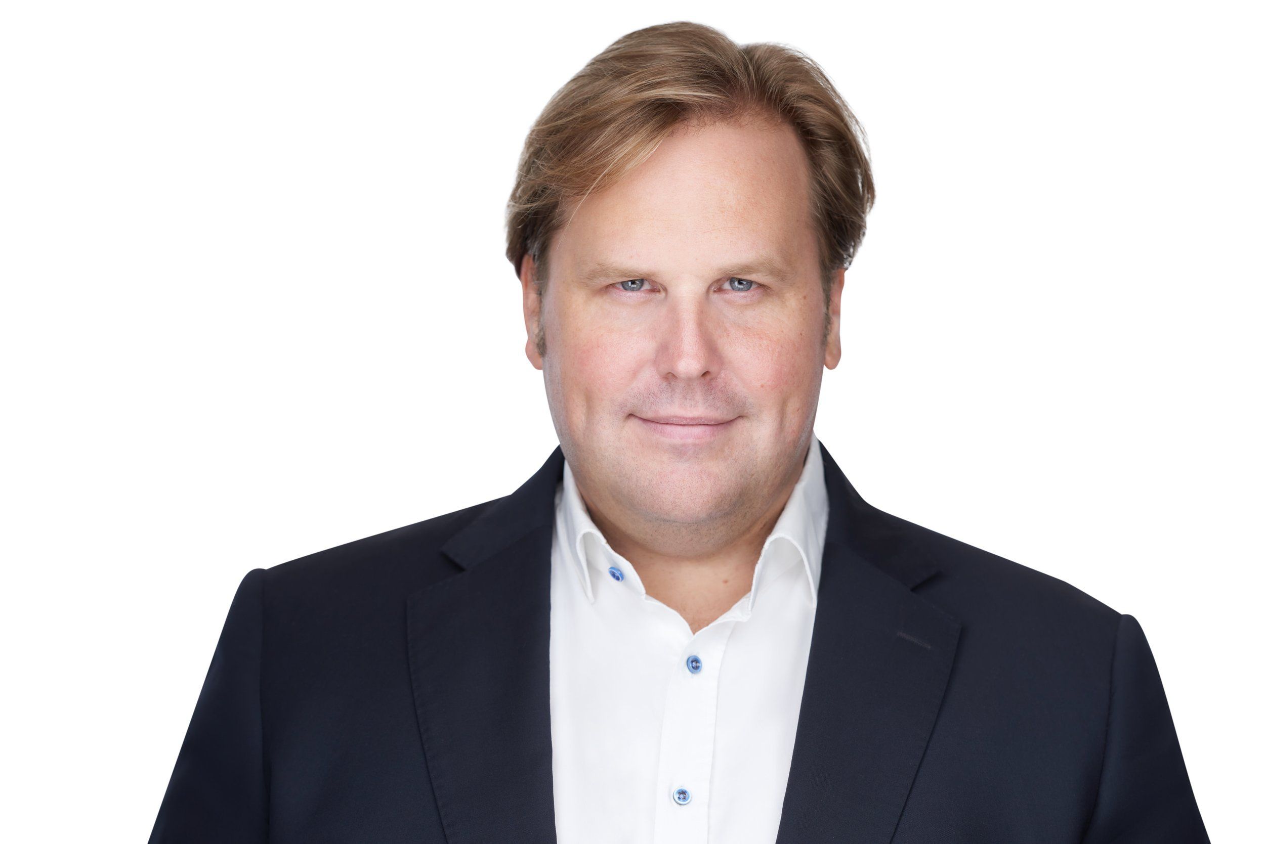 Businessportrait eines Mannes im dunklen Anzug mit weißem Hemd vor weißem Hintergrund, fotografiert im Studio in Köln